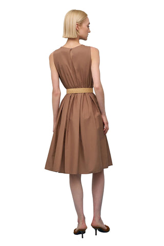 Woman wearing a brown dress against a light blue background
