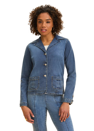 Woman wearing a denim jacket and jeans on a beige background