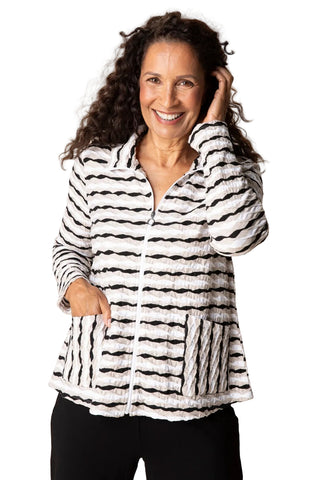 Woman wearing a black and white striped jacket against a plain background