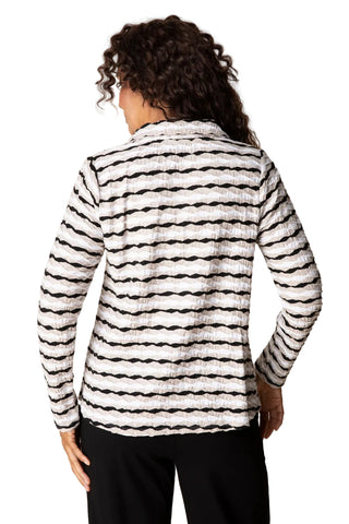 Person wearing a black and white striped jacket on a beige background