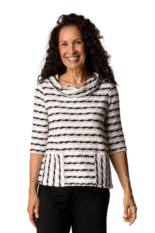 Woman wearing a black and white striped top against a beige background