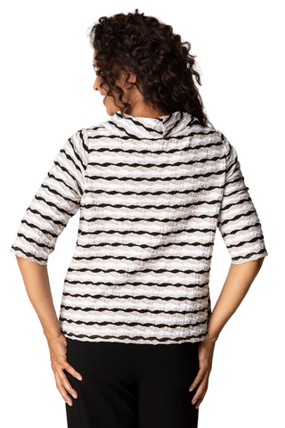 Person wearing a black and white striped shirt against a beige background