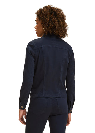 Person wearing a navy jacket and pants on a beige background