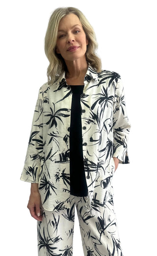 Woman wearing a black and white floral outfit against a plain background