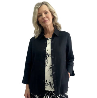 Woman wearing a black and white floral outfit against a plain background