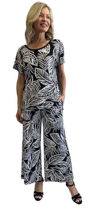 Woman wearing a black and white leaf-patterned outfit against a white background
