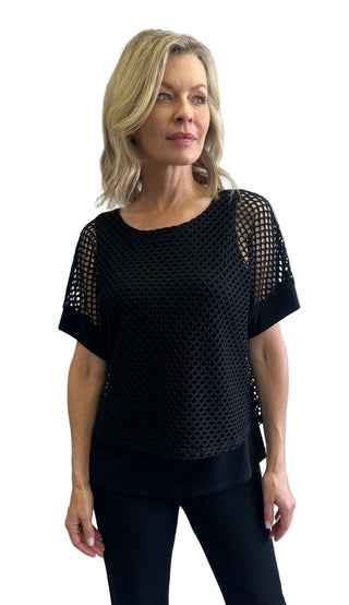 Woman wearing a black mesh top against a white background