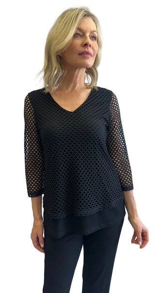 Woman wearing a black mesh top against a white background