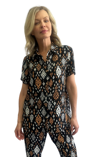 Woman wearing a black patterned dress against a white background