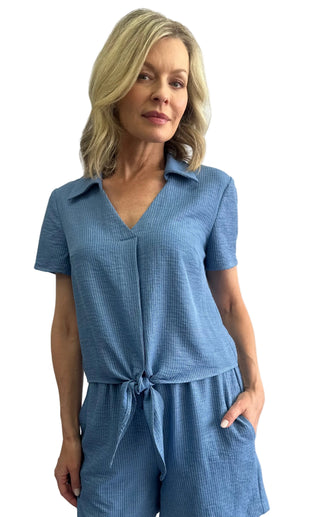 Woman wearing a blue checkered outfit against a white background