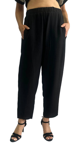 Person wearing black wide-leg pants on a plain background