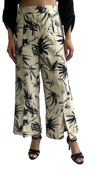 Person wearing wide-leg pants with black leaf pattern on a white background