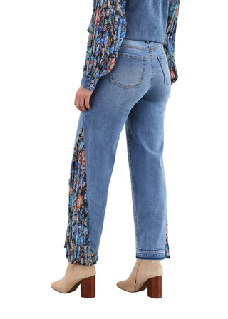 Person wearing blue jeans with floral side panels against a white background