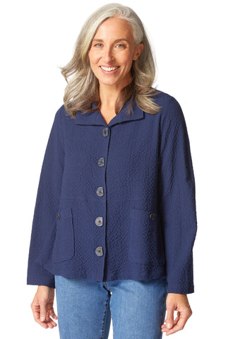 Woman wearing a blue textured jacket on a white background