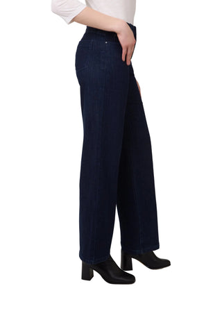 Person wearing dark blue wide-leg jeans on a plain background