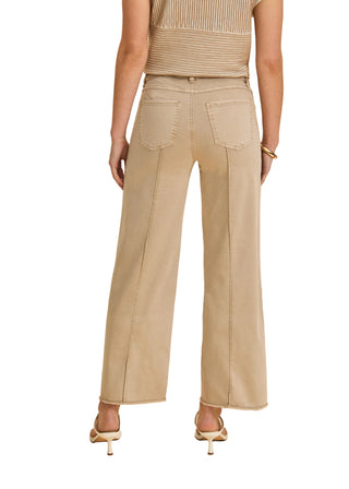 Person wearing beige wide-leg pants and a matching top on a beige background