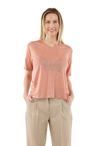 Woman wearing a pink t-shirt and beige pants on a white background