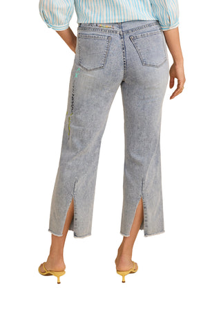 Person wearing light blue jeans with a beige background