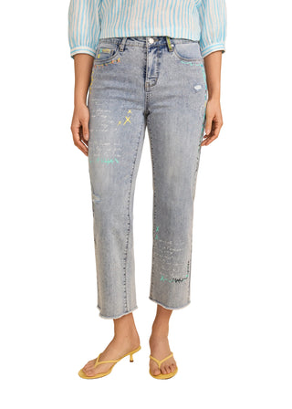 Person wearing light blue distressed jeans on a beige background