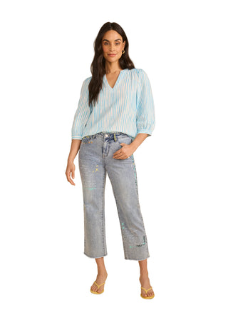 Woman wearing a striped shirt and jeans on a beige background