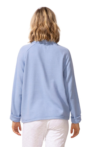Woman wearing a light blue textured sweater on a white background