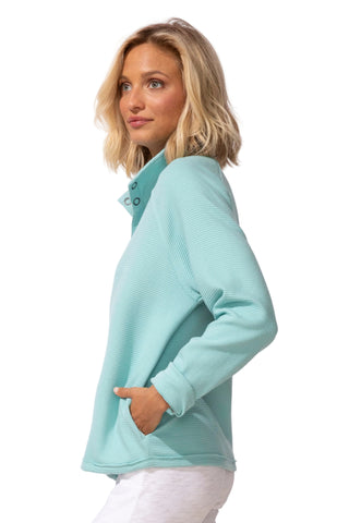 Woman wearing a light blue sweater against a white background