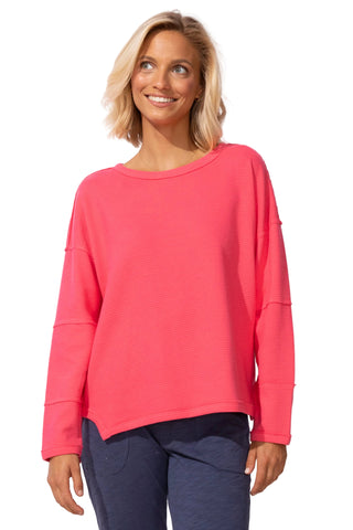 Woman wearing a pink sweater against a white background