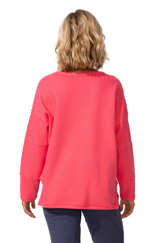 Person wearing a pink long-sleeve top on a white background