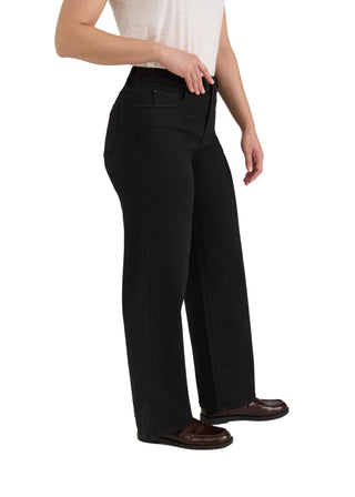 A model wearing black wide-leg trousers, styled with a white sleeveless top and dark brown leather loafers, shown from the waist down against a light gray studio background.