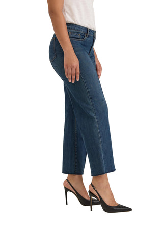 A model wearing blue cropped jeans, a white top, and black slingback high heels, shown from the waist down against a light gray studio background.