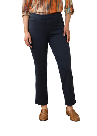 A model wearing dark navy blue cropped trousers, paired with a multicolor striped shirt and brown leather loafers, standing against a neutral studio background.