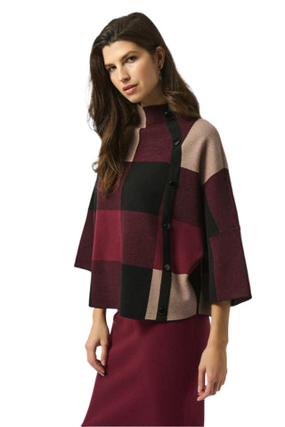Woman wearing a patterned jacket over a dress on a white background
