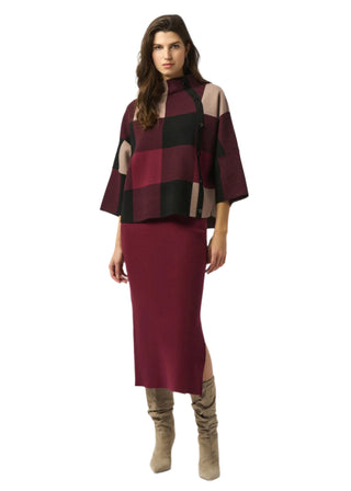 Woman wearing a burgundy and black checkered top with a matching skirt on a white background