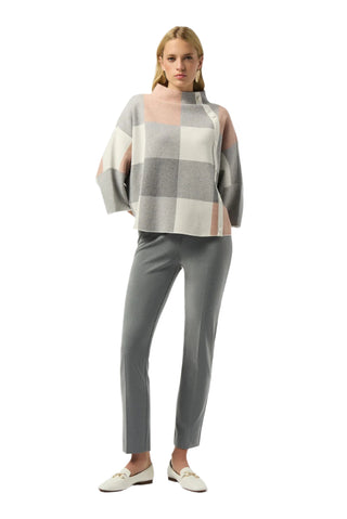 Woman wearing a checkered top and gray pants on a white background