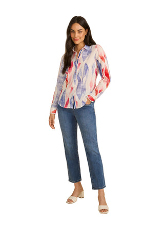 Woman wearing a colorful shirt and blue jeans on a beige background