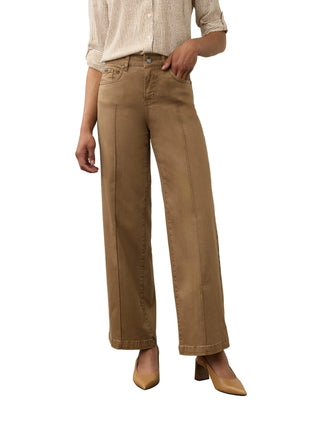 A model wearing a pair of wide-leg cropped pants in a warm tan or camel shade, paired with a cream striped shirt and beige heels, standing against a neutral studio backdrop.