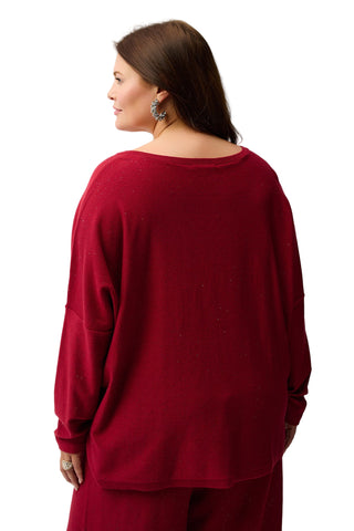 Woman wearing a red sweater and pants on a white background