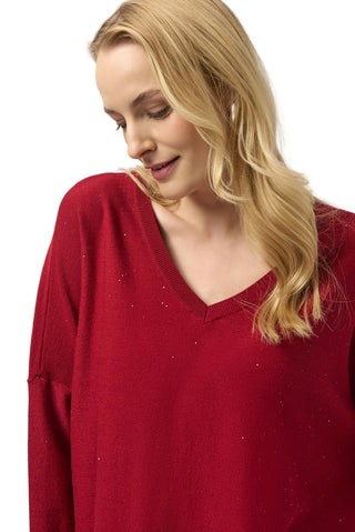 Woman wearing a red sweater against a white background