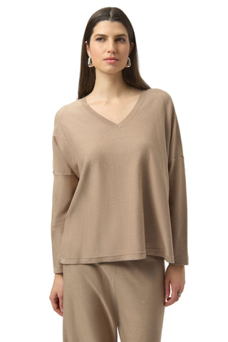 Woman wearing a beige long-sleeve top and pants on a white background