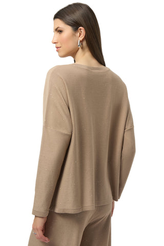 Woman wearing a beige sweater and pants on a white background