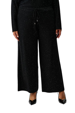 Black textured pants worn by a person on a white background
