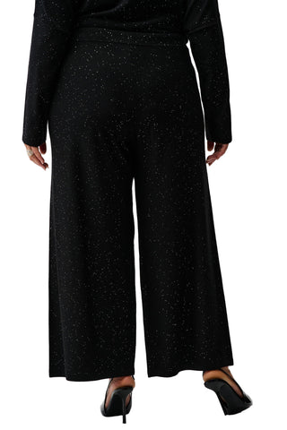 Person wearing black wide-leg pants and a long-sleeve top on a white background