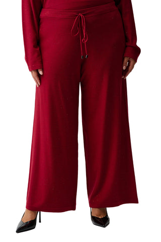 Red wide-leg pants worn by a person on a white background