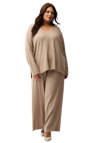 Woman wearing a beige outfit on a white background