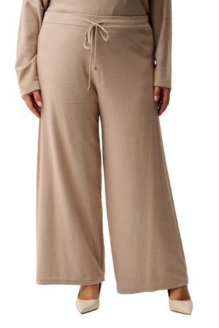 Person wearing a beige outfit with wide-leg pants on a white background