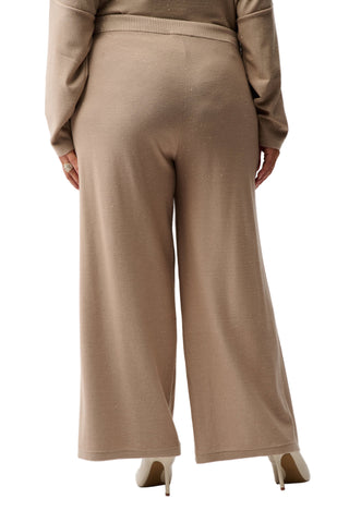 Person wearing a beige outfit with wide-leg pants on a white background