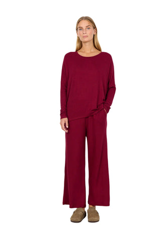 Woman wearing a burgundy outfit against a white background