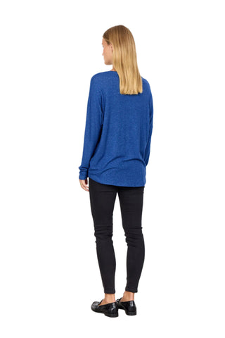 Person wearing a blue sweater and black pants against a white background