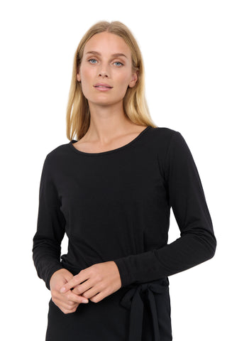 Woman wearing a black long-sleeve top against a white background
