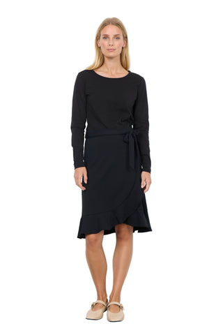 Woman wearing a black dress with a belt against a white background